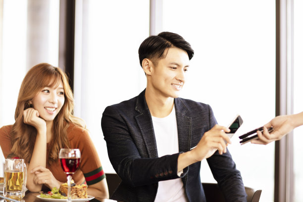 年轻人在餐馆用智能手机付款图片下载