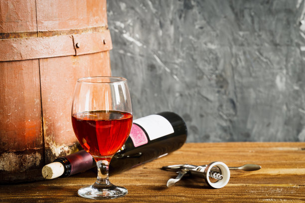 昂贵的红酒装在玻璃杯和瓶子里，木桶，放在简陋的木桌上图片下载