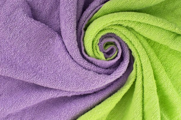扭曲的纺织品。背景是一波淡绿色和紫色的毛巾。设计的背景。图片下载