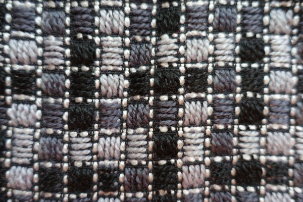 上面绣有几何图案的灰色织物图片下载