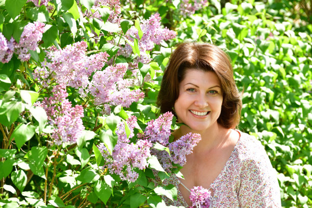 幸福的女人靠近盛开的丁香图片下载