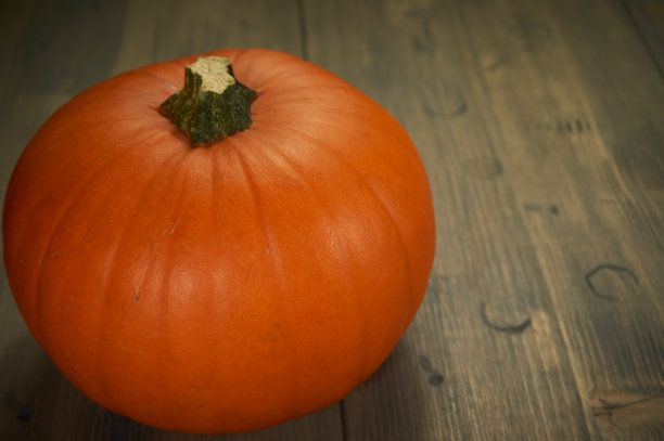 桔黄色的万圣节南瓜放在质朴的木桌上图片下载
