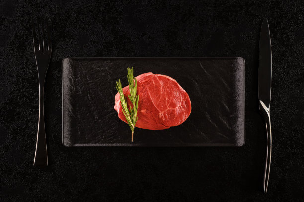 黑盘子上的生牛排。图片下载