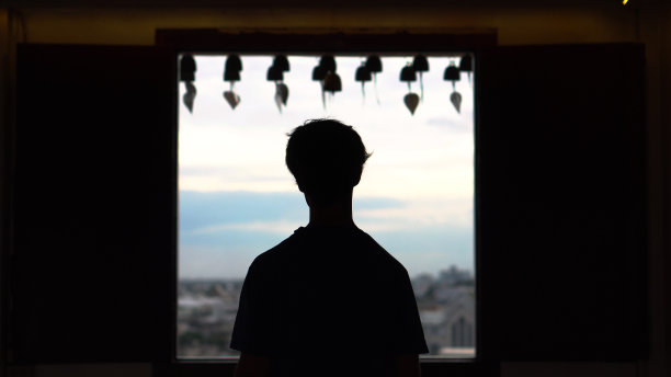 少男望窗外的剪影图片下载