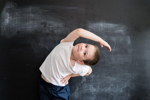 小男孩在黑板附近做运动练习。年轻的运动员。2019年日历创意设计理念。图片下载