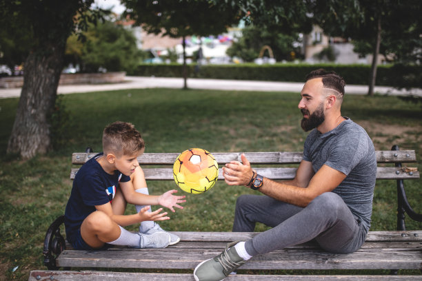 胡子父亲和他的小儿子在城市公园玩图片下载