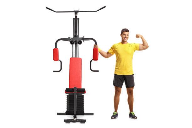 一个年轻人站在健身器旁边，在白色背景上显示孤立的二头肌图片下载