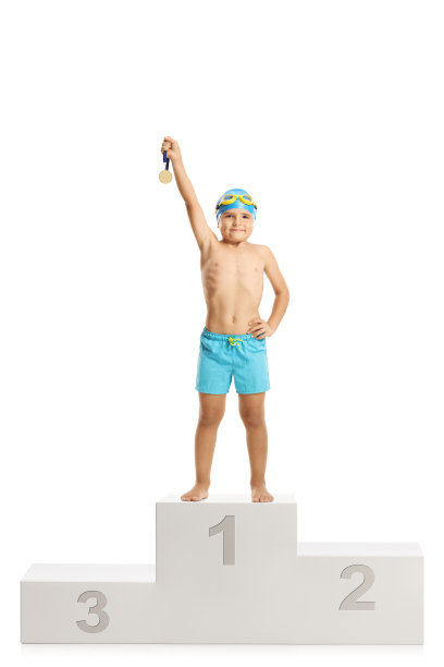 一个小男孩拿着金牌站在领奖台上图片下载