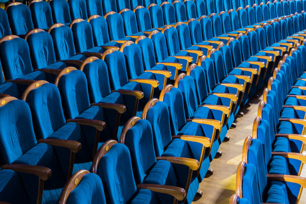 礼堂里有木制扶手的蓝色长毛绒椅子。剧院里空荡荡的礼堂图片下载