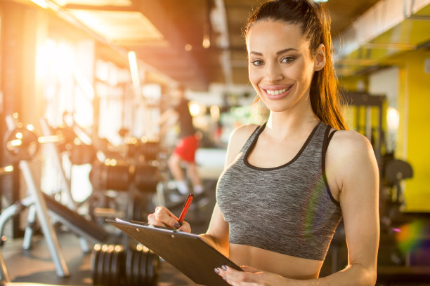 私人教练的肖像与剪贴板和笔在健身房图片下载