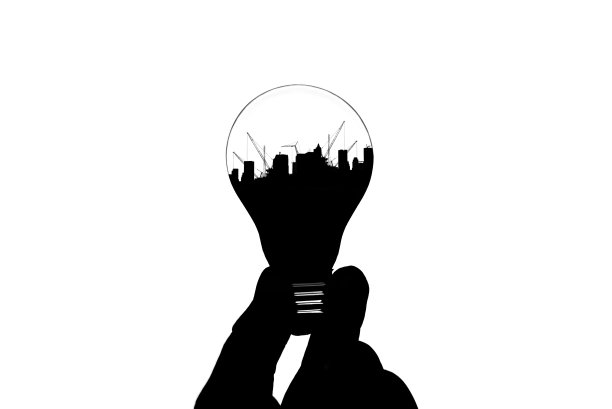 手握灯泡的剪影孤立在白色背景与起重机施工现场内图片下载