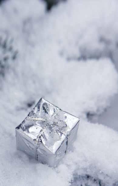 银白色的圣诞礼物在白雪上。冬天的背景图片下载