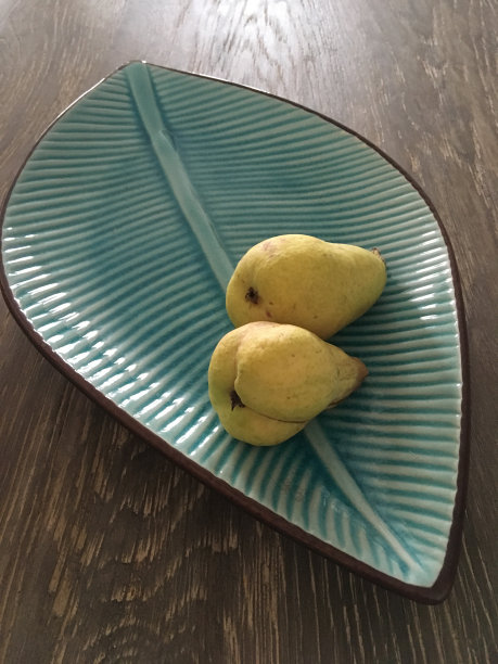 黄色瓷盘上放着两个黄澄澄的梨图片下载