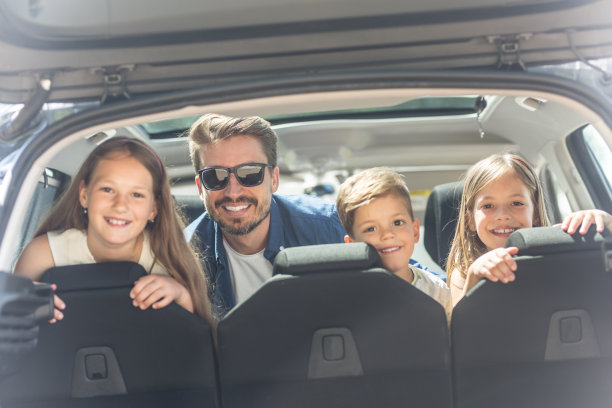 三个可爱的孩子和爸爸坐在后备箱里图片下载