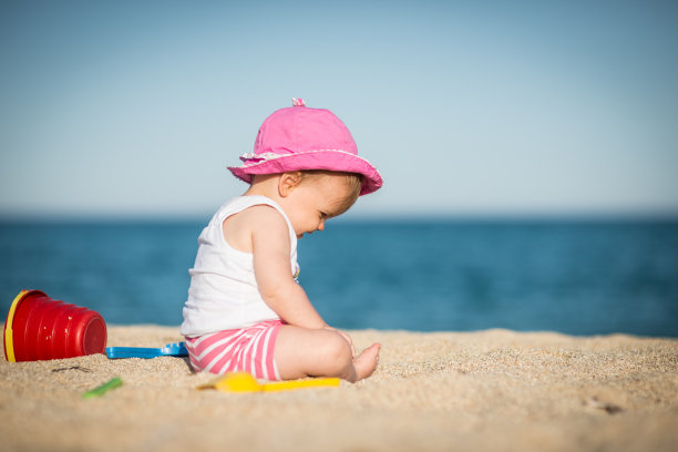 小女孩在沙子里玩巴赫的玩具图片下载