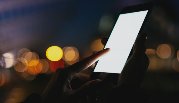 裁剪的女人的手拿着手机的空白空间屏幕为你的短信或广告内容，女性预订酒店的智能手机，而放松的户外。图片下载