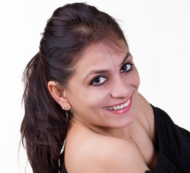 近距离的照片，一个年轻美丽的印度女人在她的30多岁穿着时尚的黑色上衣露出她的肩膀摆姿势作为一个性感的模特在白色的背景图片下载