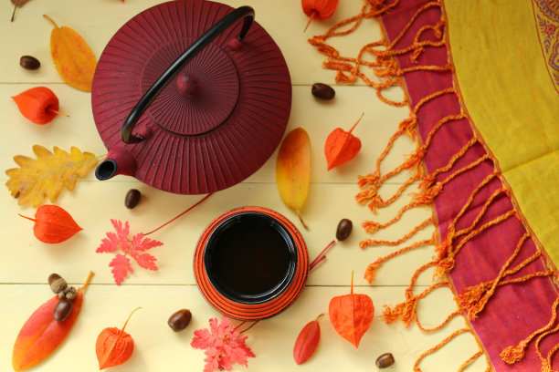 秋茶喝。勃艮第纹理茶壶，杯茶，酸浆，黄叶，橡子在黄色的木制背景。秋天的季节。秋天的时间图片下载