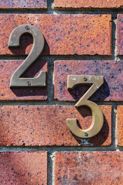 肮脏的23号的特写被拧到破旧的砖上图片下载