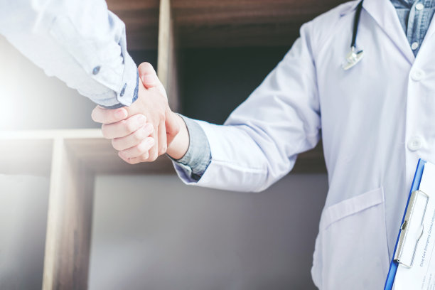 自信的医生在医院与病人握手交谈图片下载