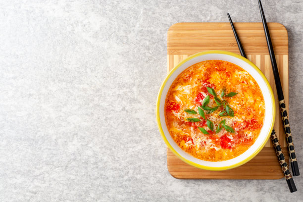 传统的中国蛋花汤，在灰色的石头背景下，番茄和葱碗图片下载