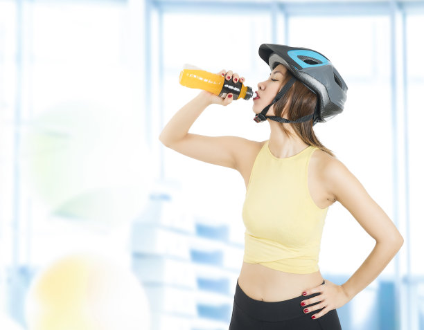 女自行车手喝一瓶能量饮料图片下载