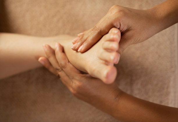 按摩师在水疗中心为女性按摩脚部。图片下载