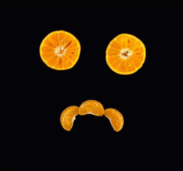 创意概念由切片的水果在黑色的背景。喜欢悲伤的脸图片下载