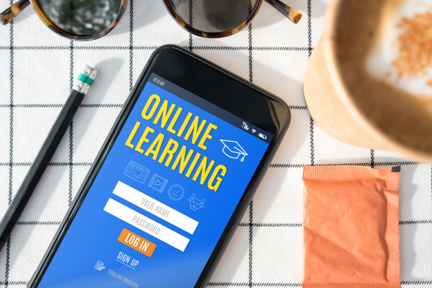 在手机屏幕上顶视图在线学习登录功能，咖啡杯，太阳镜，铅笔在白色桌布上。数字e学习。图片下载