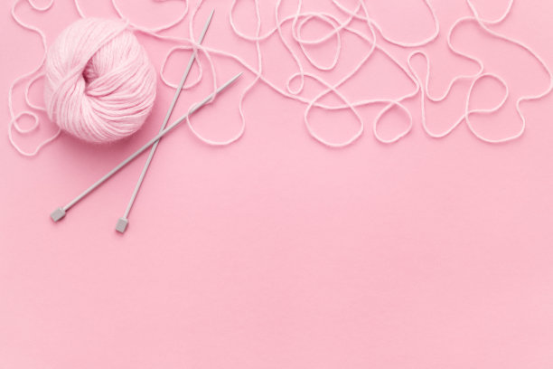 带针织针的粉红色纱线，边缘有缠结的线。图片下载