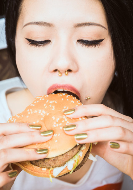 年轻的亚洲女人在吃汉堡包图片下载