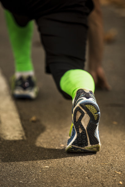 准备好了!低角度照片的男运动员的鞋在柏油路上，准备跑步。秋天的早晨图片下载