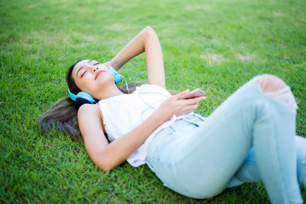年轻女子在自然公园里放松。夏天在花园里度假。图片下载