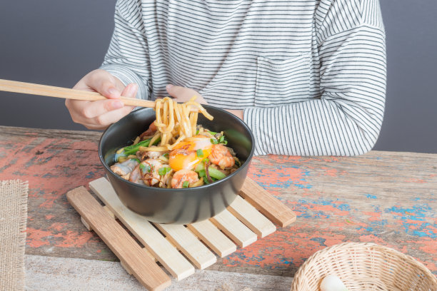 快乐的亚洲孩子吃美味的面条图片下载