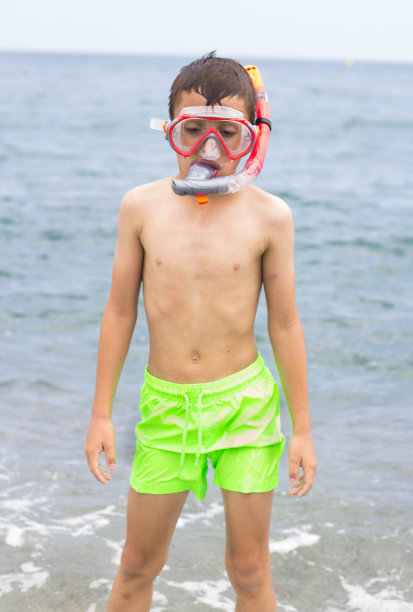 一个戴着潜水面罩的八岁小孩在海里图片下载