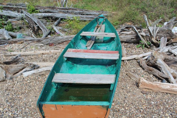 照片渔船躺在美丽的岸边的石头和沙子钓鱼和散步在河，湖。图片下载