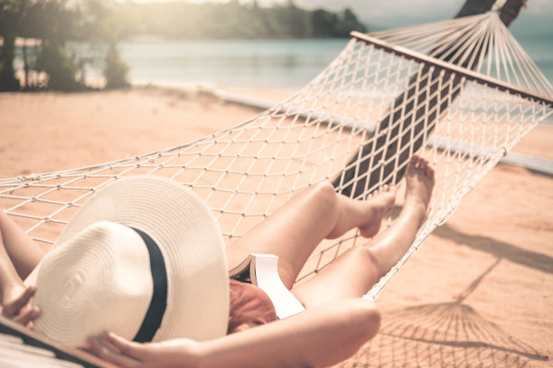 亚洲妇女放松在吊床海滩夏季假期图片下载