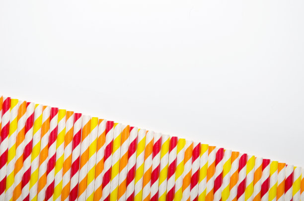 在白色的背景上排成多色的果汁吸管。拷贝空间，俯视图图片下载