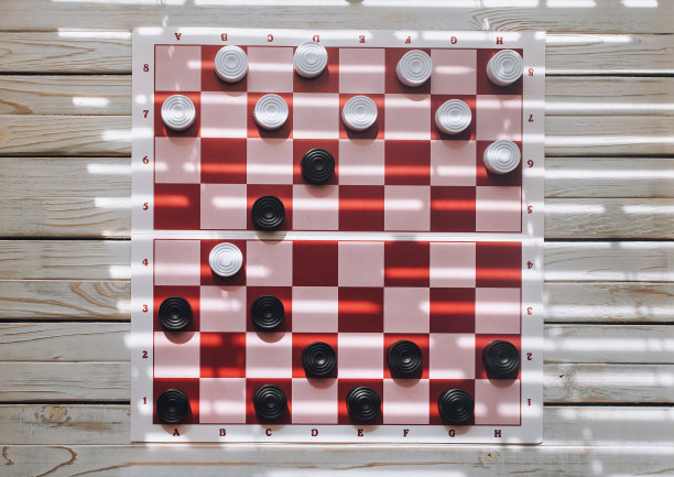 纸棋盘上的跳棋，有粉红色和红色的细胞。从以上观点。图片下载