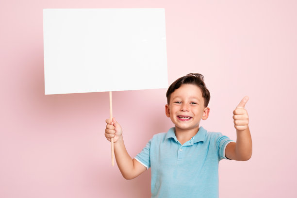 可爱的孩子拿着白色的海报。图片下载