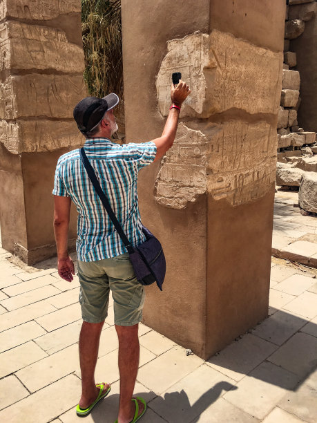 成熟的游客用手机拍摄象形文字图片下载