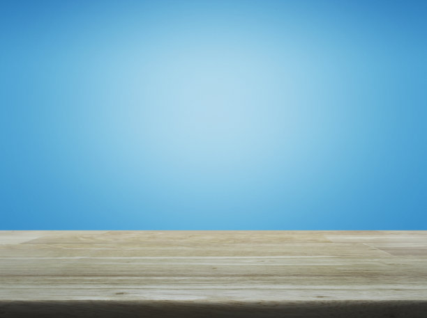 空的棕色木制桌子上方的浅蓝色渐变背景图片下载