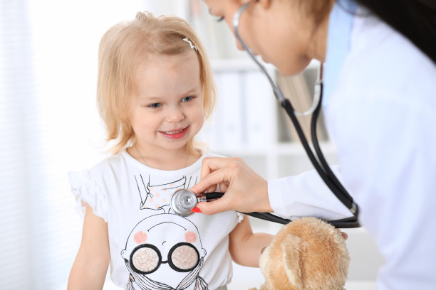 医生和病人在医院里。小儿科医生正在用听诊器给小女孩检查。医疗保健，保险和帮助的概念。图片下载