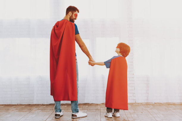 穿着超级英雄套装的父子。家庭的概念。图片下载