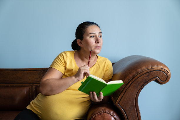 孕妇坐在客厅沙发上的肖像图片下载