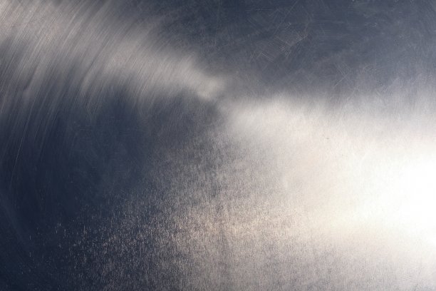 一个金属桌面的特写，在一个夏天的一天反射明亮的阳光，它的划痕和条纹从使用图片下载