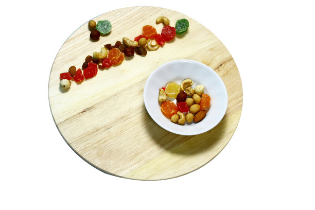 在圆板上的白色盘子里的榛子的静物。图片下载