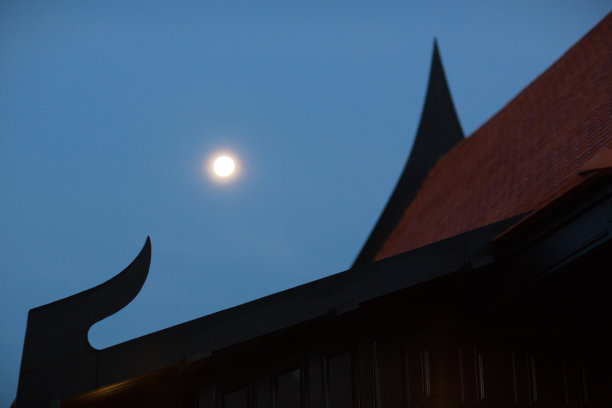 古泰式屋顶的阴影与黑暗的天空上的月亮。图片下载