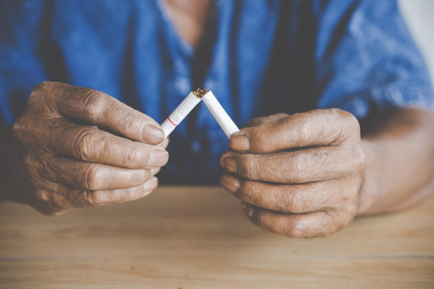 无烟日的概念是用老男性的手捏碎香烟图片下载