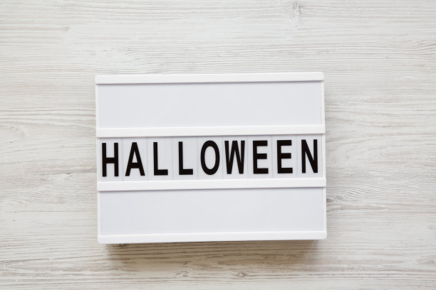 “万圣节”字灯箱上白色木质背景，俯视图。从上面的开销。图片下载